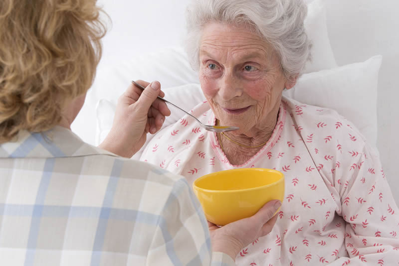 Incapacity planning demonstrated by a caregiver feeding an elderly patient